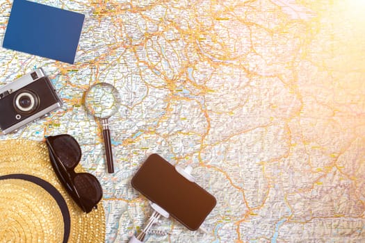 Travel plan, trip vacation accessories for trip, tourism mockup - Outfit of traveler on map background. Flat lay and copyspace. Still life. Sun flare
