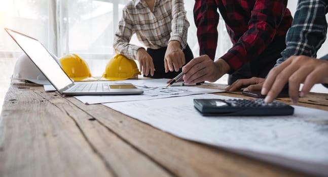 engineer people meeting working and pointing at a blueprint in office for discussing. Engineering tools and construction concept.