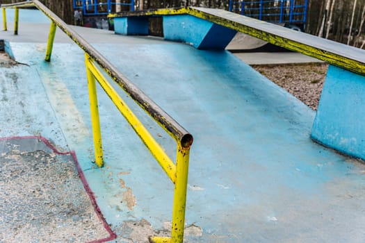 a ramp with an iron ramp for jumping in a skate park. concrete ramp for stunt scooters. The concept of a healthy lifestyle and sports leisure. extreme sports. Handrail in skate park