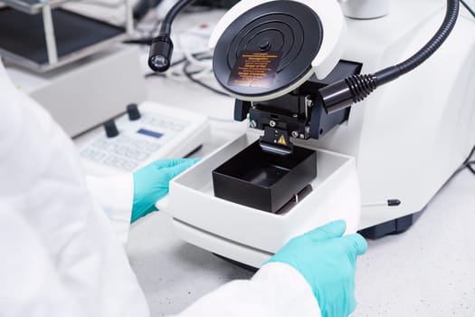 Scientist inserts the sample for biological analysis into the microscope.