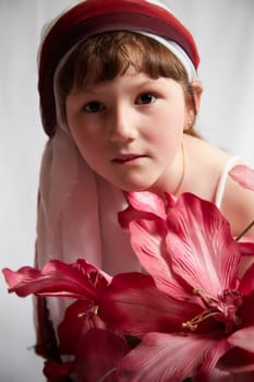 Portrait of Little girl in a stylized Tatar national costume with flowers on a white background in the studio. Photo shoot of funny young teenager who is not a professional model