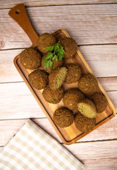 Falafel balls on a wooden cutting board and tahini sauce, High quality photo