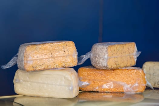 Hard cheeses. A large piece of cheese in a cheese factory, on a shelf. Production and sale of cheese. Small business concept. High quality photo