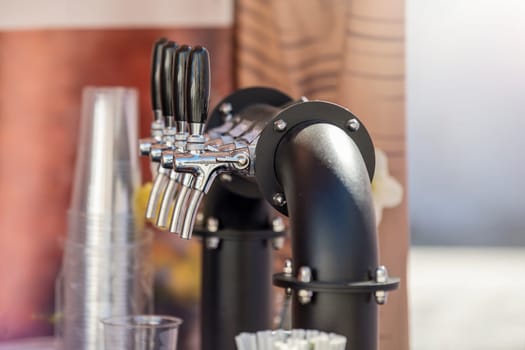 Handmade beer faucet. Bar counter in a pub with a beer tap, side view. The concept of buying, selling and drinking beer. High quality photo