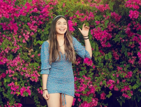 Happy young latin woman smiling in the garden. Portrait of beautiful latin girl smiling in a flower garden