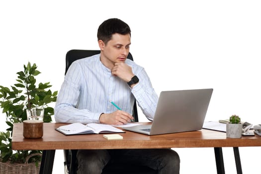 young man using laptop computer for online work at table on white background