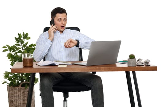 surprised businessman looking at watch while working with laptop and having phone conversation with client