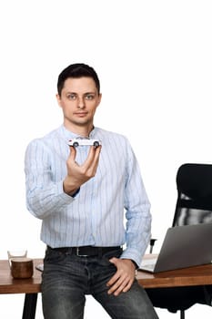 Successful caucasian businessman holding a toy car while standing at desk. Car dealerships offer car . Car insurance. focus on toy