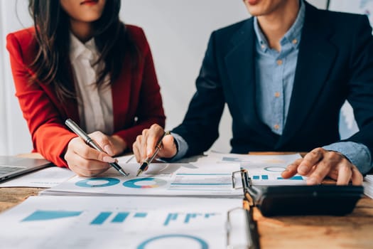 Two business people meeting to talking or discuss marketing work in workplace using paperwork, calculator, computer to work.