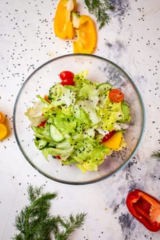 Vegetarian salad with fresh vegetables, lettuce and sesame with tomatoes top view.