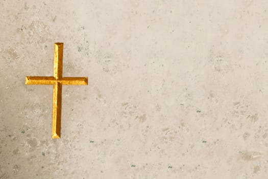 Golden cross engraved  in beige marble. With copy space. Meant as background