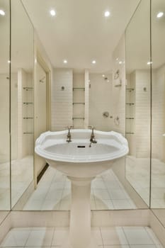 a bathroom with white tiles on the floor, and a large mirror in the corner to the wall behind it