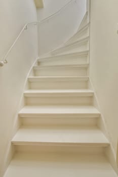some white stairs in a room with no one person on the stairs, and there is an overhead view of the staircase