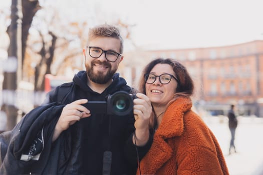 Closeup shot of young couple take selfie outdoor. Young man taking a photo with his girlfriend. Happpy smiling couple taking a selfie in a summer day.