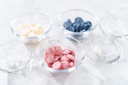 Preparing homemade chocolates. Color chocolate melts in glass pinch bowls.