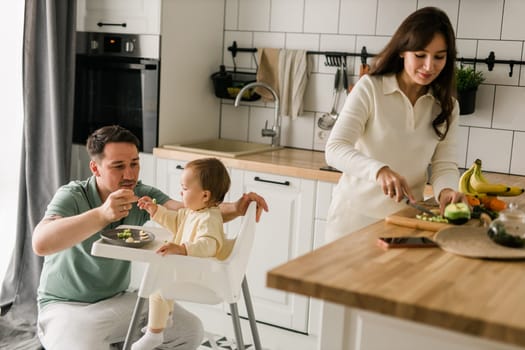 A father feeding his little baby daughter