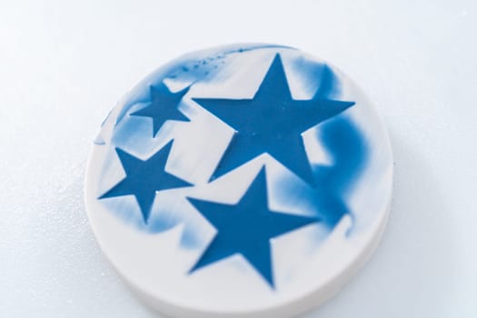 Filling star-shaped silicone mold with melted color chocolate.