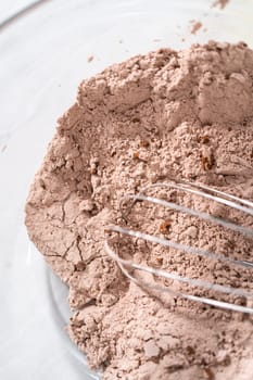 Mixing ingredients in a large glass mixing bowl to bake red velvet bundt cake with cream cheese glaze.