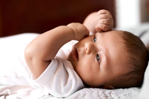 Babies bring so much cuteness into the world. an adorable baby boy lying down on a bed at home