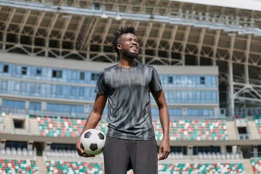 confident black football player holding the ball in his hand