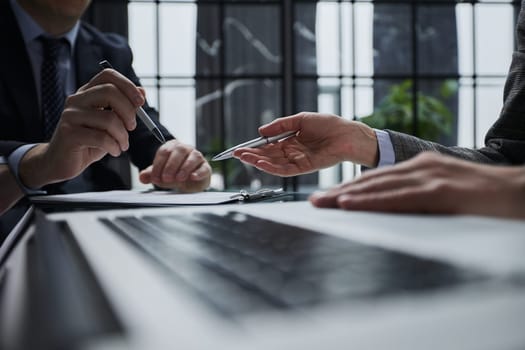 Close-up of male hands using laptop at office