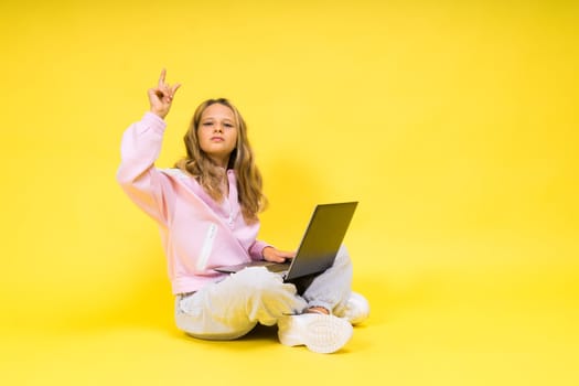 Fitness online. Girl doing stretching exercise on a floor alone with laptop at studio