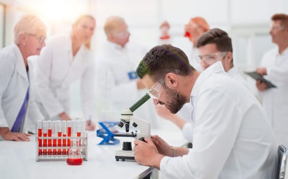 close up. smiling scientist sitting at a laboratory table .