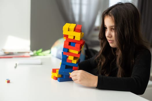 Cute little girl excites with wooden block game.