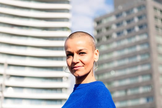 empowered woman with bald head smiling looking at camera, concept of urban lifestyle and rebel style, copy space for text