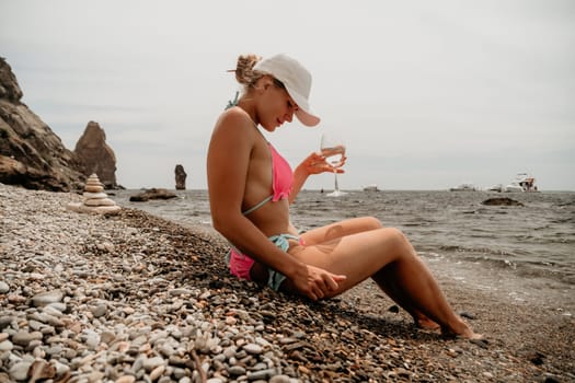 Woman travel sea. Young Happy woman in a long red dress posing on a beach near the sea on background of volcanic rocks, like in Iceland, sharing travel adventure journey