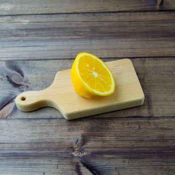 Lemon on a wooden table. Lemon cut on a dark wooden table close-up.