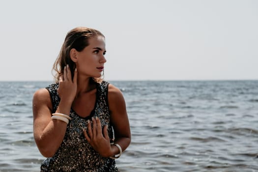 Woman travel sea. Young Happy woman in a long red dress posing on a beach near the sea on background of volcanic rocks, like in Iceland, sharing travel adventure journey