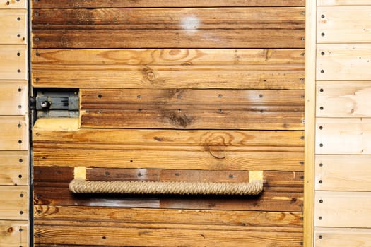 the entrance door of the workshop or garage is sheathed in wood. door handle and mortise lock. door , handle and lock