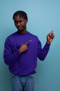positive african american young man with dreadlocks in a blue sweatshirt.