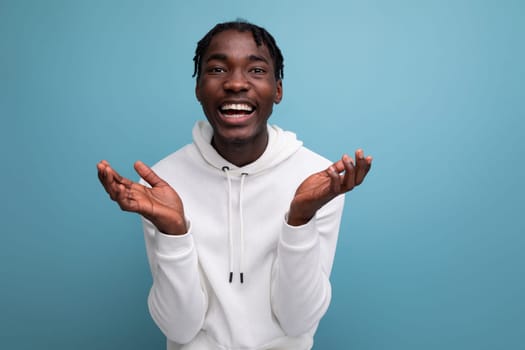 positive dark skinned young brunette male with hollywood smile on studio isolated background.