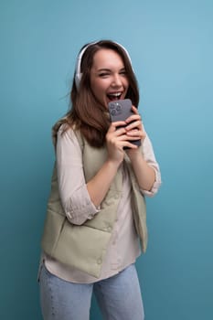 energetic young brunette woman relaxing to music using headphones and mobile phone.
