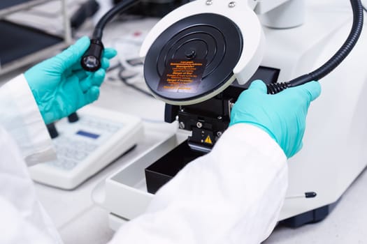 Scientist inserts lamps of microscope for focusing on a specimen.