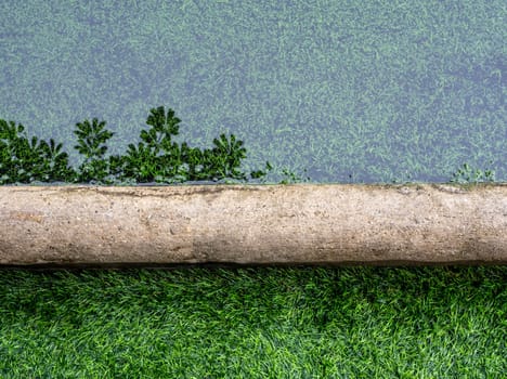 The reflection of tree in the flooding water surface on the border of artificial grass football field