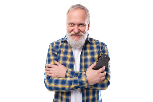 handsome 50s mid aged gray-haired man with a beard in a shirt with a smartphone on a white background.