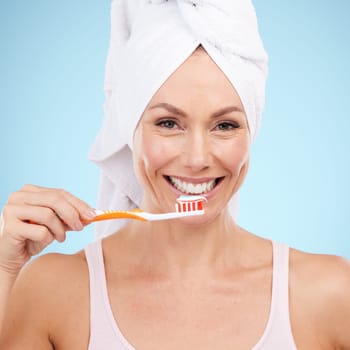 Portrait, woman smile and toothbrush isolated on blue background for dental, mouth or orthodontics health. Beauty model or mature person for brushing teeth, cleaning product and toothpaste in studio.
