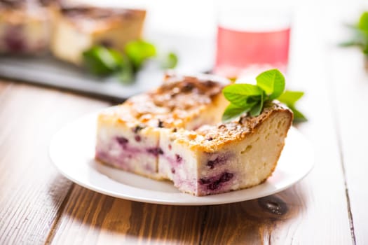 cooked cottage cheese casserole with berry filling in a plate on the table