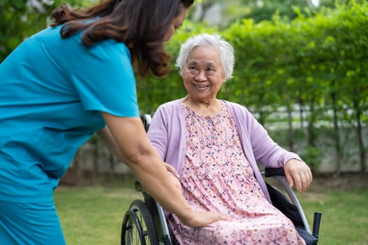 Doctor help and care Asian senior woman patient sitting on wheelchair at park in nursing hospital ward, healthy strong medical concept.