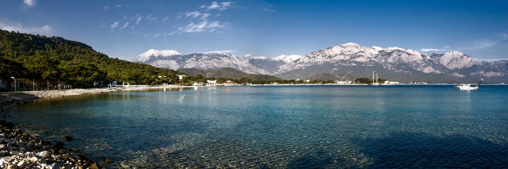 Kemer Antalia nice view of the sea. Beach Kemer Antalia with sand and mountains, the sea with the ship. Beautiful harbor near the sandy beach.