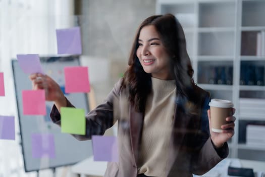 Beautiful young teen asian businesswoman using note pad thinking with planning working on financial document, tax, exchange, accounting and Financial advisor.