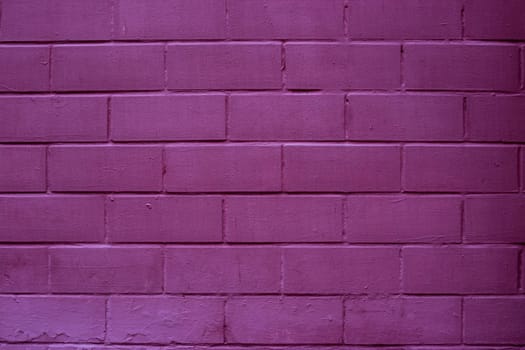 Painted brick wall in pink purple paint texture stone background.