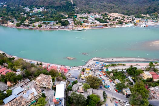 aerial drone shot over ram setu jhula suspension bridge with temples on the bank of river ganga in the holy spiritual city of Rishikesh Haridwar uttarakhand india