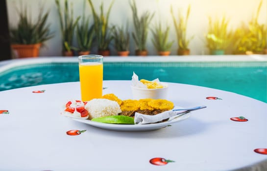 Vacation breakfast near a swimming pool, Delicious breakfast near a crystal clear pool, Traditional breakfast with orange juice near a swimming pool