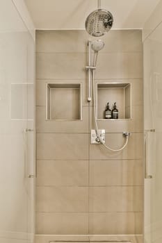 a bathroom with a shower head mounted on the wall, and a white toilet in the photo is taken from above