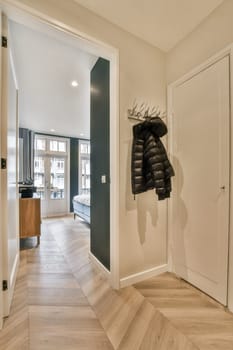 an entry way with a coat rack hanging on the wall and two doors in the hallway leading to the living room