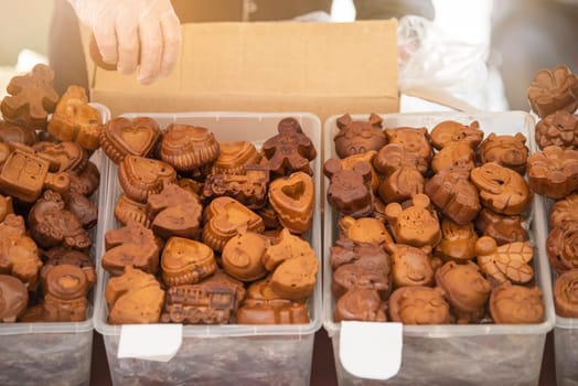 Selection of fresh shaped cookies at the market. A man puts cookies of various shapes on the counter in a pastry shop. Festive baking. High quality photo